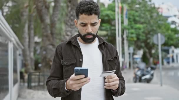 Joven Barbudo Comparando Una Tarjeta Crédito Con Smartphone Una Calle — Vídeos de Stock