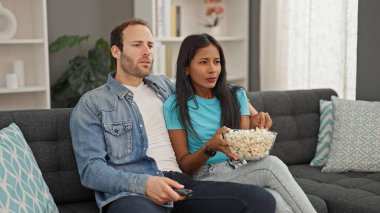 Evde oturmuş mısır yiyen güzel bir çift.