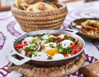 Taze, geleneksel bir Shakshuka tabağı. İçinde domates, yumurta ve sebzeler var. Kahvaltı için hazır..