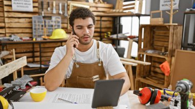 Önlüklü sakallı adam bir marangozun çalışma masasında otururken sohbete daldı..