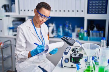 Afrikalı Amerikalı kadın bilim adamı. Laboratuvarda kendine güveni tam bir yazı.