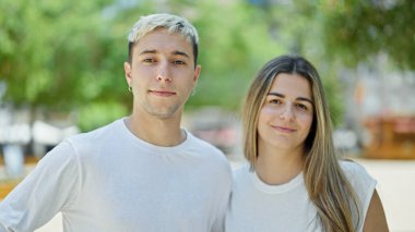 Parkta bir arada durarak gülümseyen güzel bir çift.