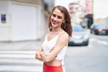 Sokakta kollarını kavuşturmuş genç, güzel İspanyol bir kadın.