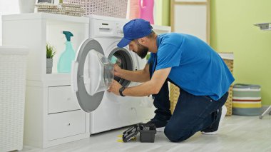 Çamaşırhaneyi temizleyen genç İspanyol teknisyen.