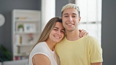 Güzel bir çift gülümsüyor. Evde birbirlerine sarılıyorlar.