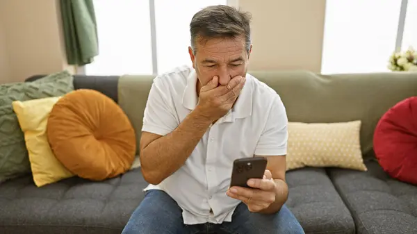 Zaniepokojony Mężczyzna Średnim Wieku Korzystający Smartfona Nowoczesnym Salonie — Zdjęcie stockowe