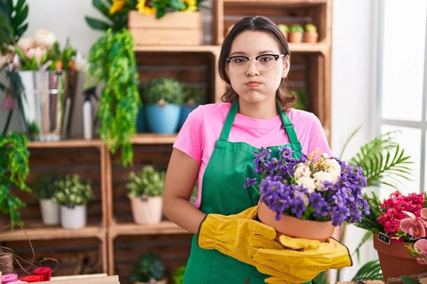 Hispanic Young Woman Working Florist Shop Holding Plant Puffing Cheeks — Stock Photo, Image