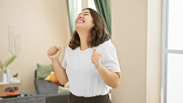 Laughing Young Hispanic Woman Celebrating Joyfully Cozy Home Interior — Stock Photo, Image