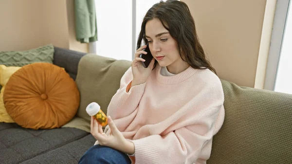 Düşünceli Genç Bir Kadın Evde Bir Kanepede Oturur Telefonda Konuşurken — Stok fotoğraf