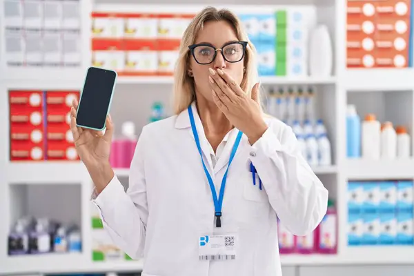Young Blonde Woman Working Pharmacy Drugstore Showing Smartphone Screen Covering — Photo