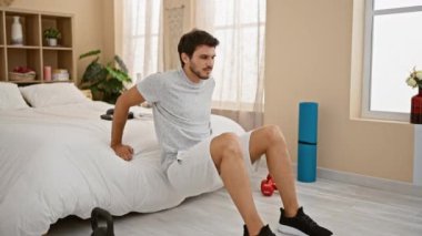 Yakışıklı adam yatak odasını esnetiyor spor yapıyor rahatlıyor rahat bir ev..