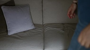 Orta yaşlı, gri saçlı, elinde uzaktan kumandayla koltukta televizyon seyretmeye hazır bir adam..