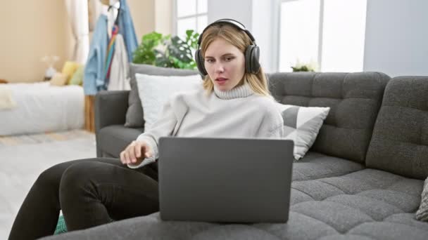 Uma Mulher Loira Gosta Música Fones Ouvido Enquanto Usa Laptop — Vídeo de Stock