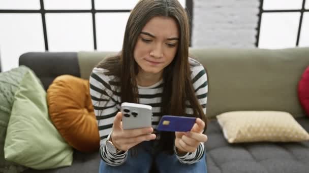 Adolescente Hispano Sosteniendo Una Tarjeta Crédito Teléfono Inteligente Preocupado Mientras — Vídeos de Stock