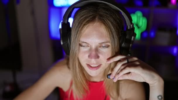 夜の暗い部屋でゲームヘッドセットを着用する集中した白人女性 — ストック動画