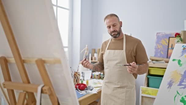 Handsome Young Adult Artist Choosing Perfect Paintbrush Standing Art Studio — Stock Video