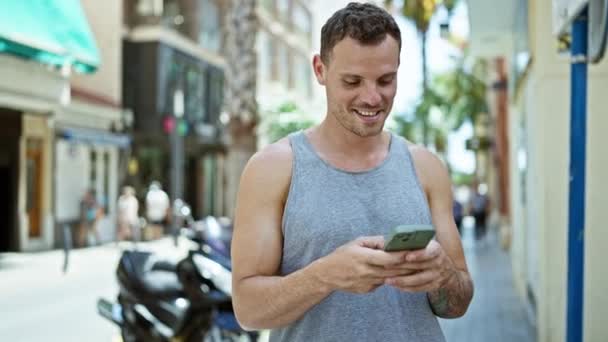 Χαμογελώντας Άνθρωπος Τατουάζ Χρησιμοποιώντας Smartphone Ηλιόλουστο Αστικό Δρόμο — Αρχείο Βίντεο