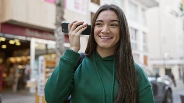 Leende Ung Latinamerikansk Kvinna Som Håller Telefon Mot Örat Gata — Stockvideo