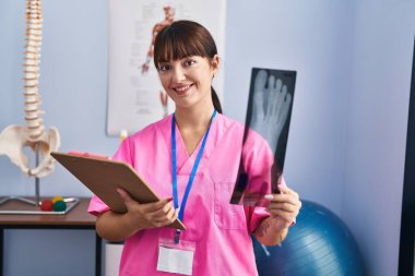 Genç, İspanyol bir kadın fizyoterapist. Rehabilitasyon kliniğinde röntgen çekiyor.