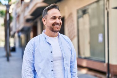 Young caucasian man smiling confident looking to the side at street