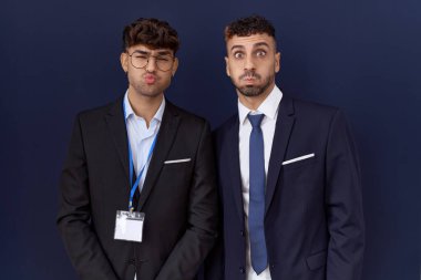 İki İspanyol iş adamı iş kıyafetleri giyip komik suratlarıyla yanak şişiriyorlar. Havayla şişmiş ağız, çılgın bir ifade.. 