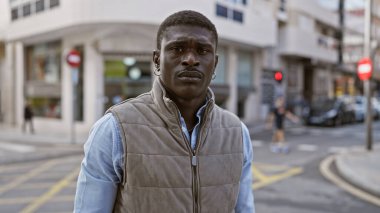 Yakışıklı Afrikalı bir adam kentin zarafetini ve tarzını somutlaştıran, kendine güvenen bir caddede duruyor..