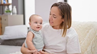 Annesinin sevgi dolu gülümsemesi, kızıyla birlikte evde rahat bir hayat sürerken neşeli bir kahkahayla gülmesi.