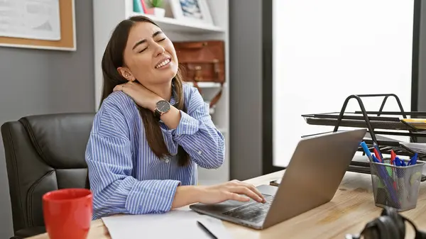 在现代办公室的笔记本电脑上工作时 迷人的年轻惊慌失措的女人感到脖子疼痛 — 图库照片
