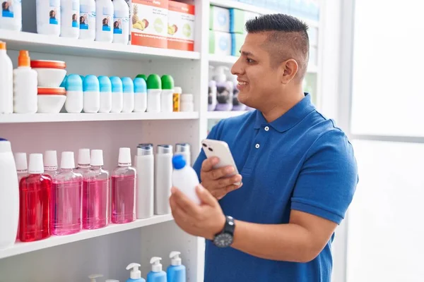 Young latin man customer make photo by smartphone to medicine bottle at pharmacy