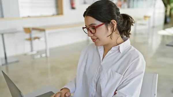 Een Jonge Spaanse Vrouw Werkt Aandachtig Een Laptop Een Heldere — Stockfoto