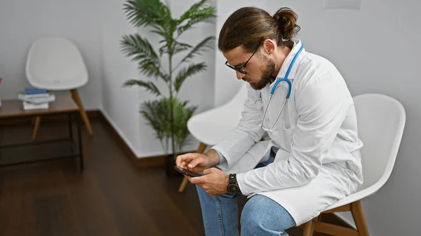 Ung Latinamerikansk Man Läkare Använder Smartphone Arbetar Kliniken Väntrum — Stockfoto