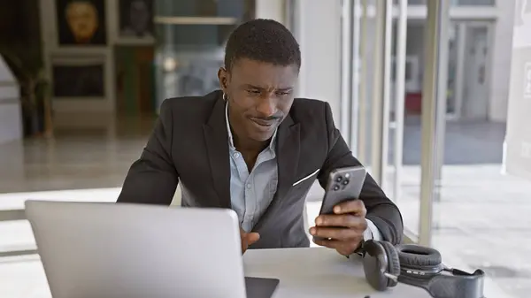 Profesionální Africký Muž Obleku Pracující Laptopem Smartphonem Moderním Kancelářském Prostředí — Stock fotografie