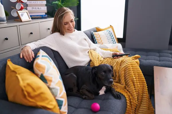 Young Blonde Woman Watching Movie Sitting Sofa Dog Home — Foto Stock
