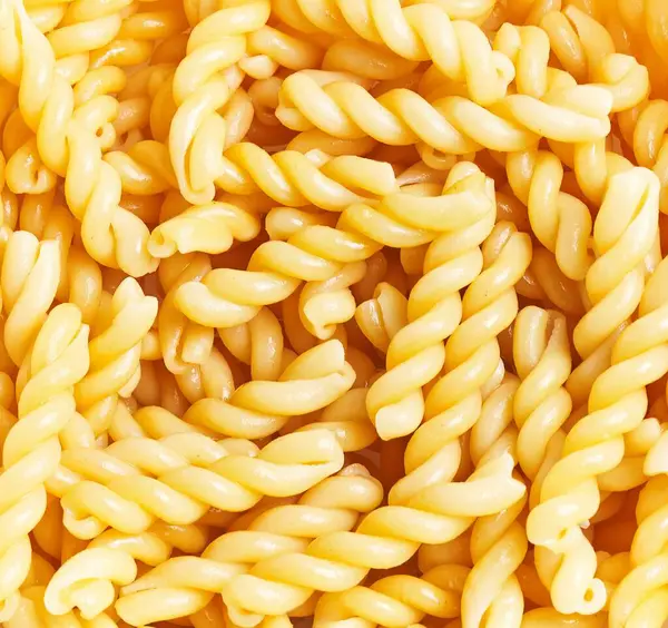 Close Uncooked Fusilli Pasta Forming Textured Yellow Background Ideal Culinary — Stock Photo, Image