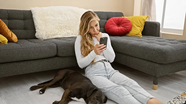 Donna Bionda Con Smartphone Sdraiata Accanto Labrador Addormentato Accogliente Soggiorno — Foto Stock