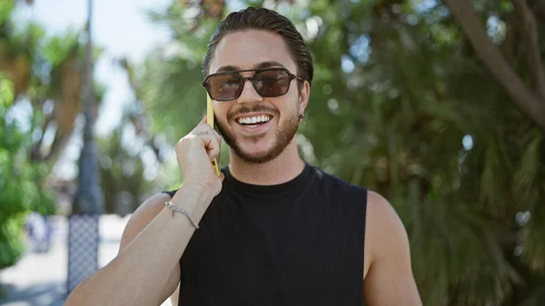 Junger Hispanischer Mann Mit Sonnenbrille Plaudert Park Mit Smartphone — Stockfoto