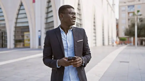 Afro Amerikalı Adam Gülümsüyor Elinde Akıllı Telefon Tutuyor — Stok fotoğraf