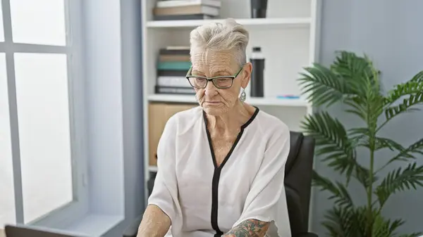 Oudere Grijsharige Vrouw Een Vastberaden Zakenman Concentreert Zich Haar Laptopwerk — Stockfoto