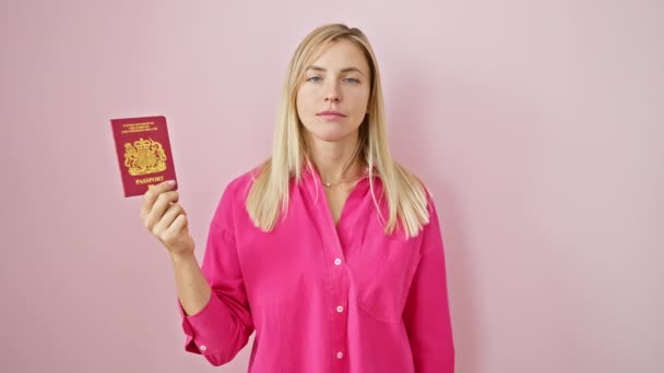見事なブロンドの若い女性 北アイルランドの大人のパスポート所有者は 孤立したピンクの上に怒って親指を下げます 紛れもない で表現された嫌悪と拒絶 サイン — ストック動画