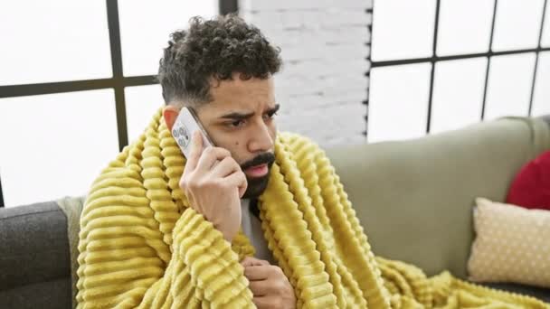 Заинтересованный Молодой Человек Бородой Делает Телефонный Звонок Завернутый Желтое Одеяло — стоковое видео