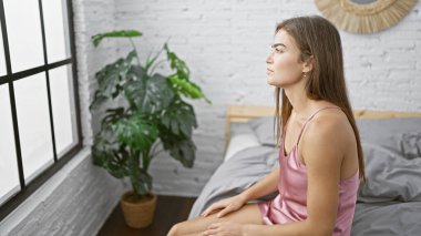 Yatak odasının mahremiyetinde, yatakta oturan genç ve güzel bir İspanyol kadın üzüntülü bir ifadeyle, ciddi bir konsantrasyonla şüphelerini dile getiriyor..