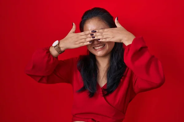 Asyalı Genç Bir Kadın Kırmızı Arka Planda Duruyor Gözleri Kaplıyor — Stok fotoğraf