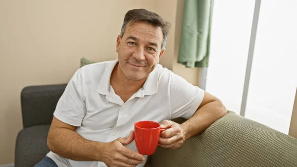 Middle Aged Man Holding Mug Smiles Warmly Well Lit Living — Stock Photo, Image