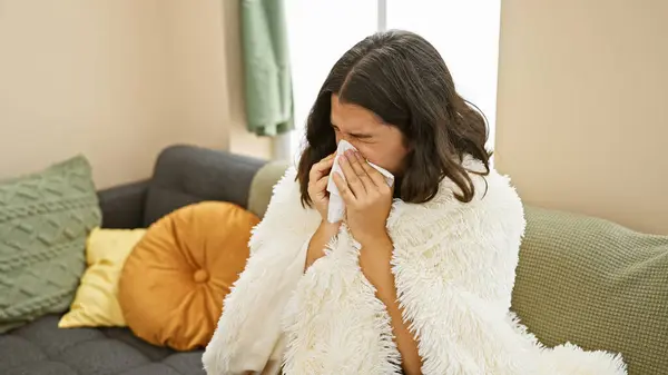Young Hispanic Woman Sneezing Tissue While Wrapped Cozy Blanket Sofa — Stock Photo, Image