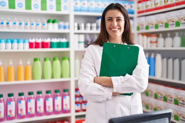 Young Beautiful Hispanic Woman Pharmacist Smiling Confident Holding Clipboard Pharmacy — Stockfoto
