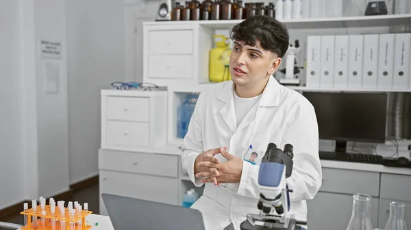 Young Man Wearing Lab Coat Sits Contemplatively Modern Laboratory Filled — Stock Photo, Image