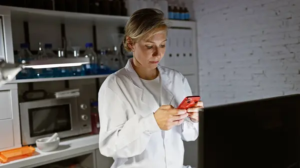 Vit Kvinna Forskare Med Hjälp Smartphone Laboratorium Inomhusmiljö Omgiven Laboratorieutrustning — Stockfoto