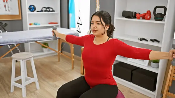 Young Hispanic Woman Exercises Dumbbells Indoors Rehabilitation Clinic — Stock Photo, Image