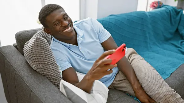 Fešák Černošky Muž Pomocí Smartphone Směšně Moderním Obývacím Pokoji Nastavení — Stock fotografie
