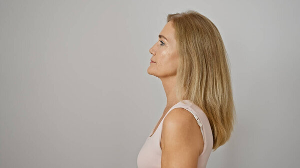 Side-profile of a middle-aged caucasian blonde woman against an isolated white background.